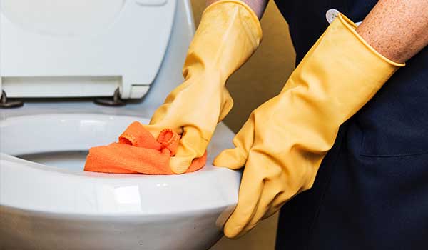 Person scrubbing toilet by hand